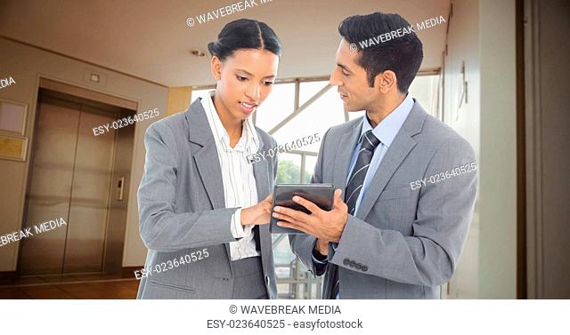 Composite image of business people discussing over digital tablet
