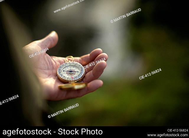 Close up man holding compass