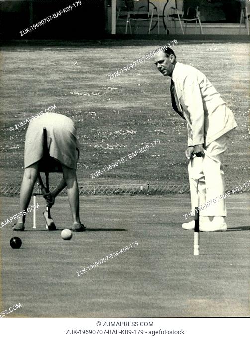 Jul. 07, 1969 - Open Croquet Championships At Hurlingham Club. Photo Shows: As the u-pire looks on Mrs. Rotherham, the leading woman player took up this unusual...