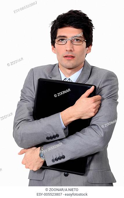 A businessman hugging his briefcase