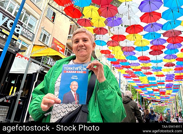 TURKEY, ANKARA - MAY 26, 2023: A woman shows a leaflet promoting Turkish presidential candidate Kemal Kilicdaroglu in a street
