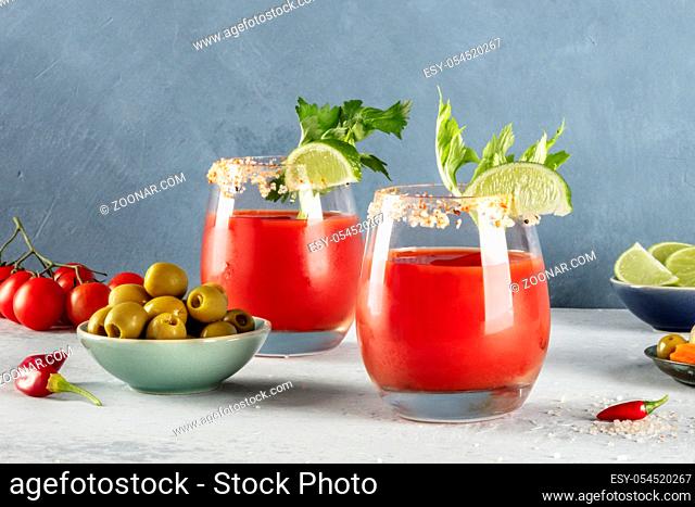 Bloody Mary cocktail with tomato juice, lime, and celery, with olives
