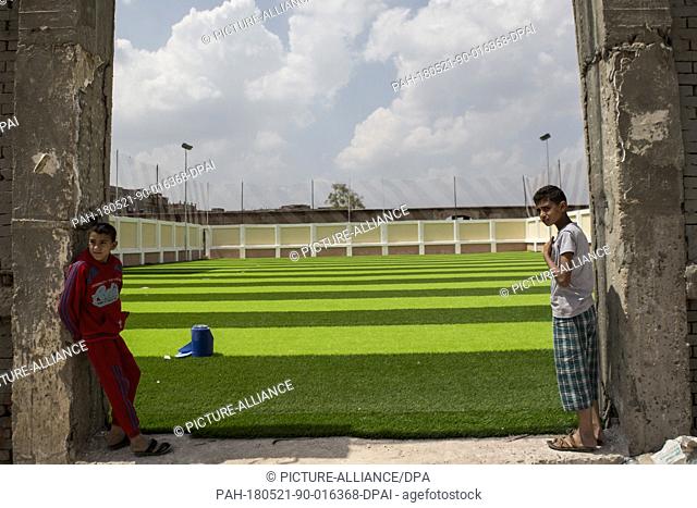 dpatop - A picture made available on 21 May shows Egyptian boys standing at the entrance of a new football field, sponsored by Liverpool's Mohamed Salah