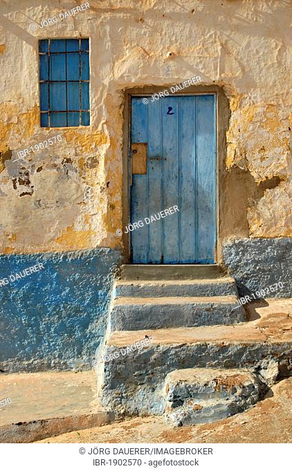 A blue door and a blue window on a white facade in Sidi Ifni, Morocco, Africa