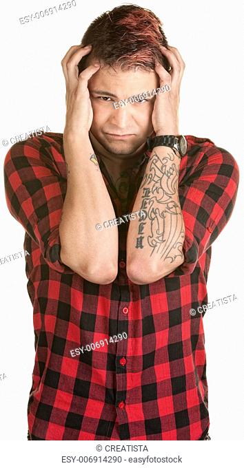 Young male in flannel shirt holding his head