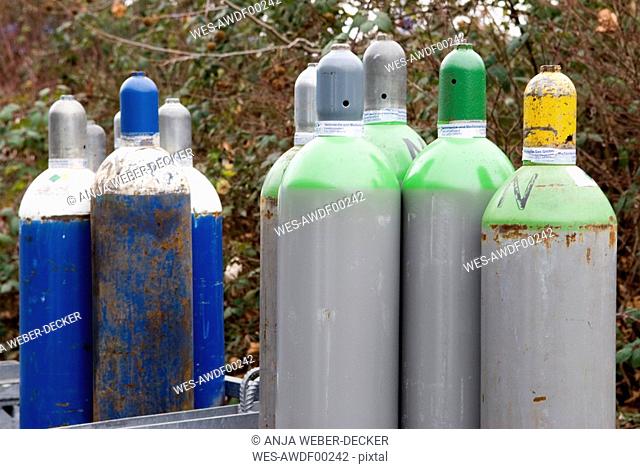 Group of rusty refillable metal gas bottles