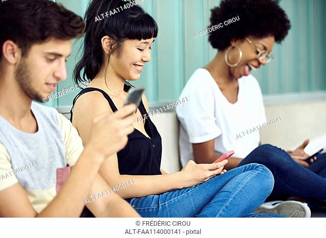 Friends hanging out and looking at smartphones