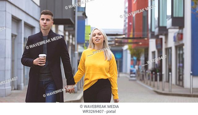 Couple holding hand and walking on street