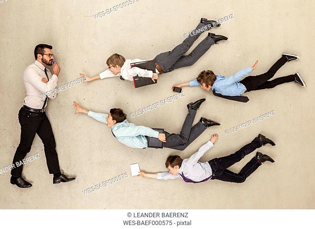 Businessman confused while boys in mid air