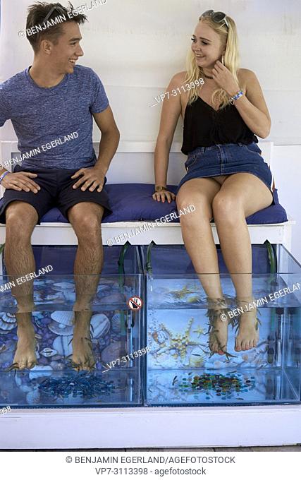 couple at Fish Spa, Fish Therapy, pedicure, foot massage. In holiday destination Chersonissos, Crete, Greece