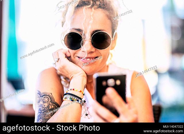 portrait of cheerful modern young woman using cell phone smiling outdoor - online female people looking at cellular device and have fun - happy female connected