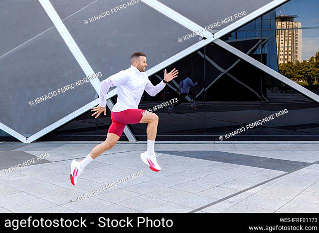 Fit male athlete running on footpath