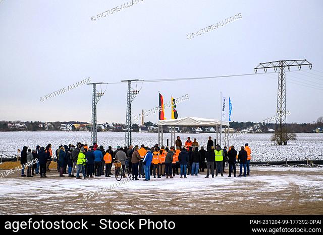 04 December 2023, Saxony-Anhalt, Niedere Börde: Participants in a symbolic ground-breaking ceremony for the next section of the A14 north of Magdeburg stand on...