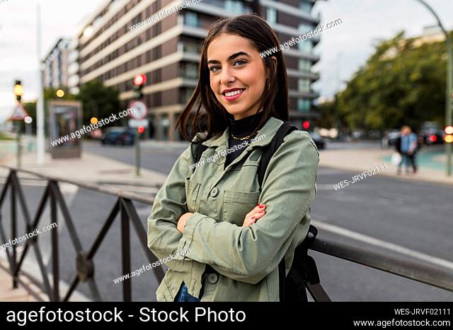 Woman with arms crossed leaning on railing