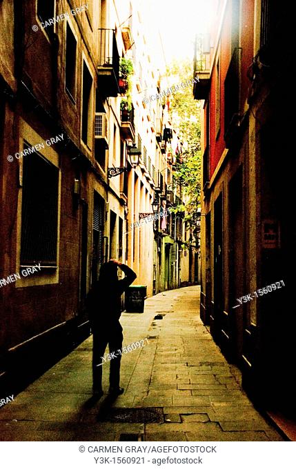 Boy taking a picture in a narrow street in the gothic area. Barcelona