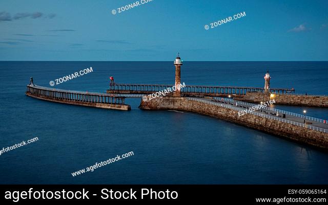 Evening light over the Whitby harbour and pier in North Yorkshire, England, UK - seen from the East Terrace