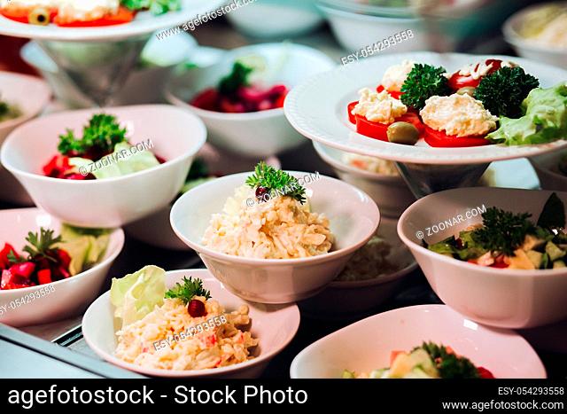View of many round plates with tasty vegetables dish of salads with tomato, onion, zucchini, tomato and herbs. Big delicious for dinner in restaurant