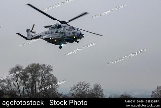 30 November 2023, Bavaria, Donauwörth: An NH90 Sea Tiger combat helicopter flies over the airfield of the Airbus Helicopters plant during its maiden flight
