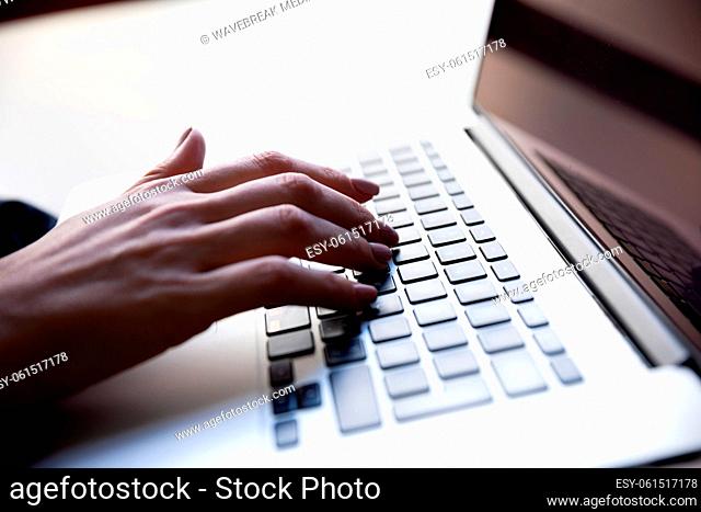 Mid section of woman using laptop