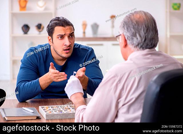 Young man visiting old jeweler