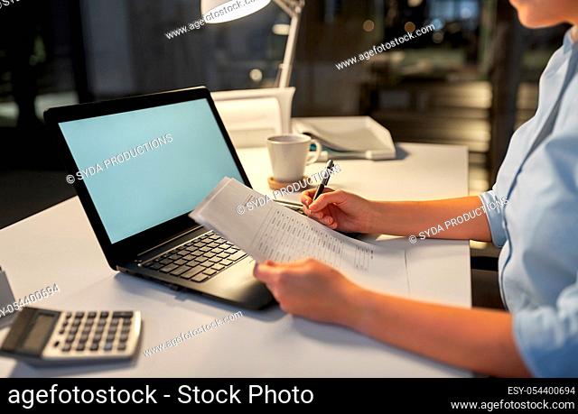 businesswoman with papers working at night office