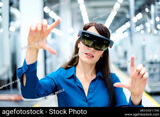 Businesswoman using augmented reality eyeglasses at industry