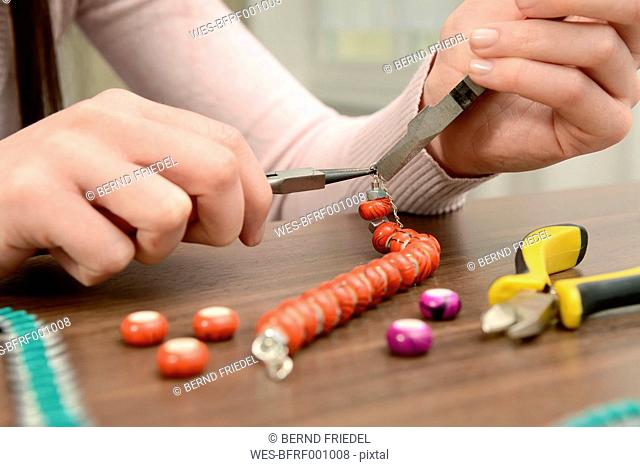 Young woman working on self-made bracelet