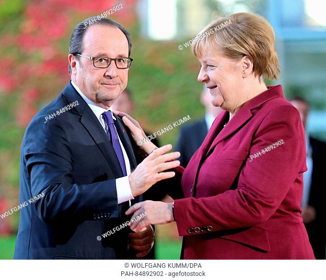 German chancellor Angela Merkel greets the president of France, Francois Hollande for the Ukraine summit in front of the German Federal Chancellery in Berlin