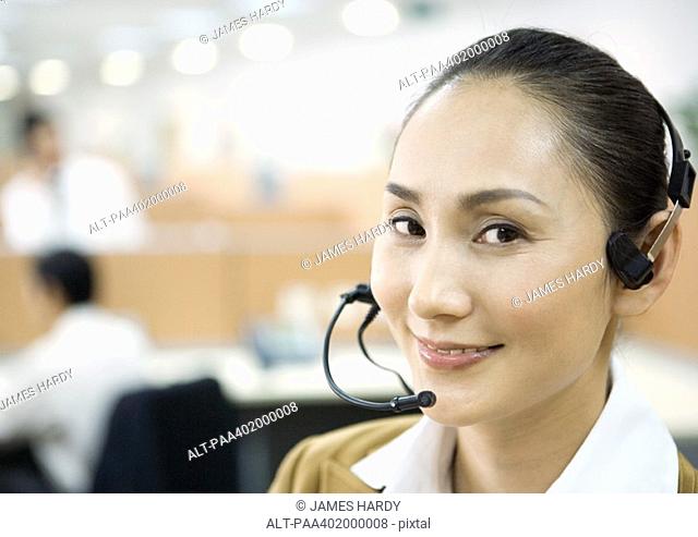 Woman wearing headset, smiling at camera