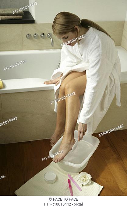 A blonde woman cleaning her foot