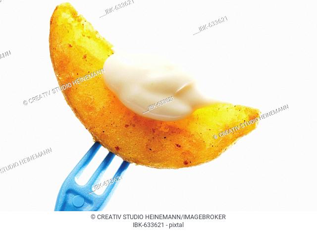 Potato wedge with mayonnaise on fork