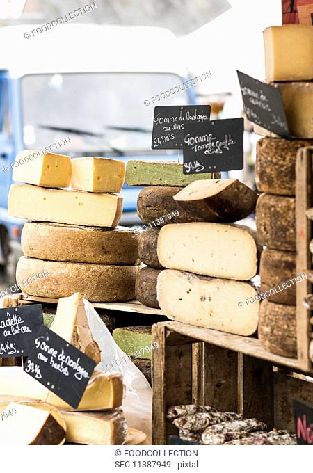 Various cheeses on a market stall