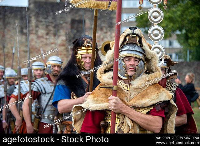 17 September 2022, Rhineland-Palatinate, Trier: Legionary reenactors of the 1st Roman Cohort Opladen move across a meadow of the Imperial Baths