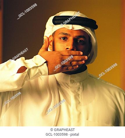 Arab man covering his mouth with his hand