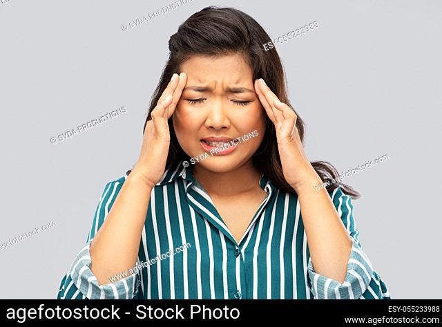 stressed asian woman holding to her head