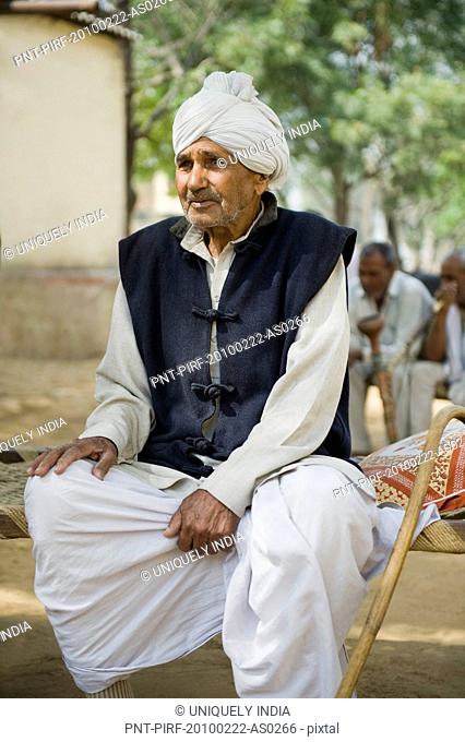 Farmer sitting on a cot, Hasanpur, Haryana, India