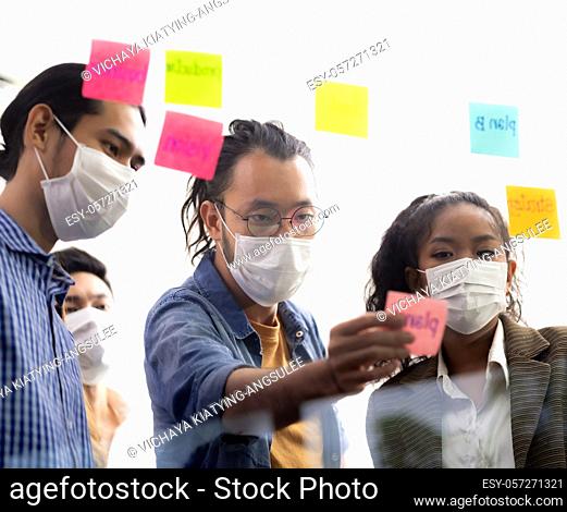 Interracial asian business team brainstorming idea at office meeting room after reopen due to coronavirus COVID-19 city lockdown