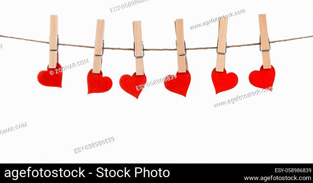 Clothes pegs and red paper hearts on rope isolated on white background Valentines day concept