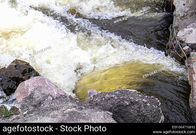 River rapids. Close up abstract background of falling water. Water flows over river rocks. A beautiful powerful stream of a stormy mountain river