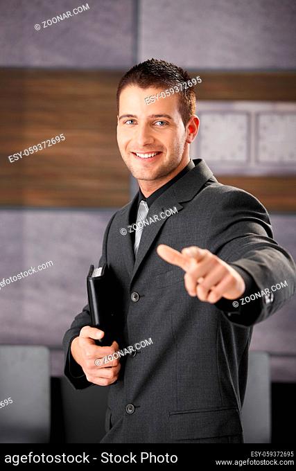 Successful young businessman smiling happily, having organizer