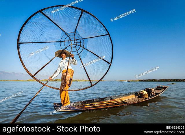 Myanmar travel attraction landmark, Traditional Burmese fisherman with fishing net at Inle lake in Myanmar famous for their distinctive one legged rowing style