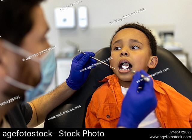 Dentist at work. Dentist examining little boys oral cavity