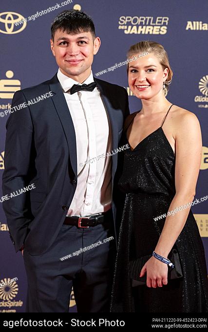 19 December 2021, Baden-Wuerttemberg, Baden-Baden: Dennis Kudla (l) arrives with girlfriend Simone at the gala for the election of the ""Sportsman of the Year""...