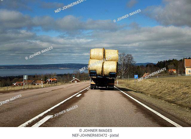 Lorry with bales of straw on a road, Dalarna, Sweden