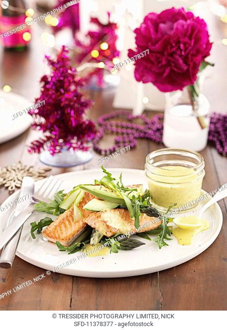 Fried salmon on a vegetable salad with avocado, asparagus and rocket