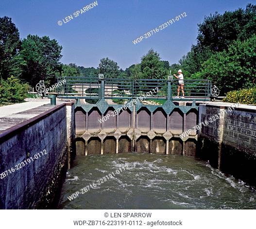 A boatng tourist operating the lock gates on the River Charente in the Poitou region of France