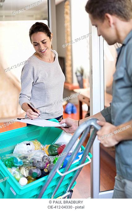 Woman signing for delivery in kitchen