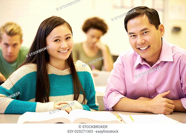 Female High School Student With Teacher Studying At Desk