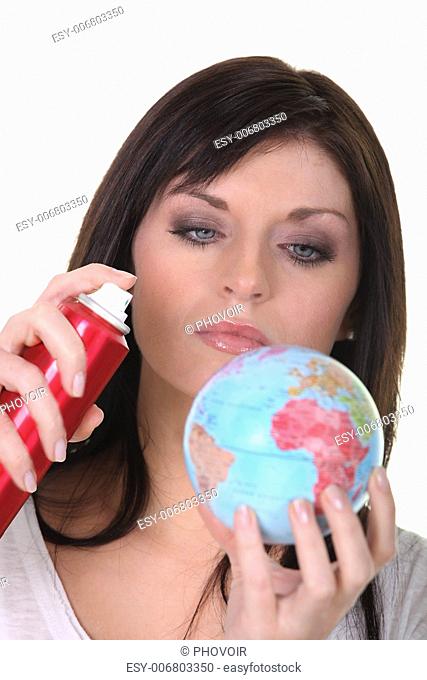 Woman spraying miniature globe