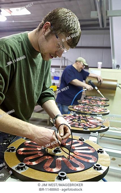 Worker assembles the generators of Windspire wind turbines; the Windspire is a small, vertical axis wind turbine designed for residential or small business use